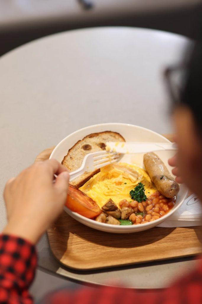 a person sitting at a table with a plate of food